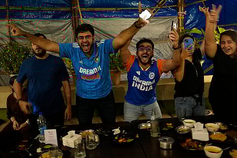 Cricket fans cheer during live coverage in Mumbai